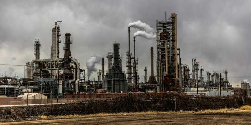 Image of a large factory with several chimneys with a grey sky in the background, used to show pyrolysis.