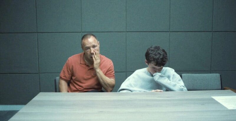 Scene from Adolescence depicting the boy and his father in an interrogation room, both visibly distressed, reflecting the show’s raw emotional realism.