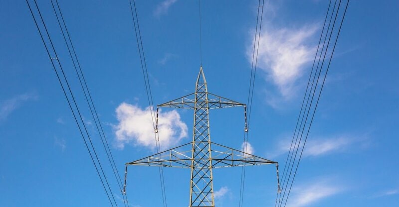 Torre de líneas de transmisión eléctrica vista en contrapicado con cielo despejado, IELO