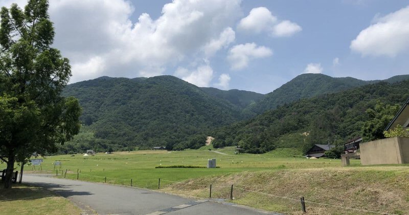 滋賀県マキノ高原(牧野スキー場）のゲレンデ側キャンプサイトの風景とマキノ高原温泉さらさの建物