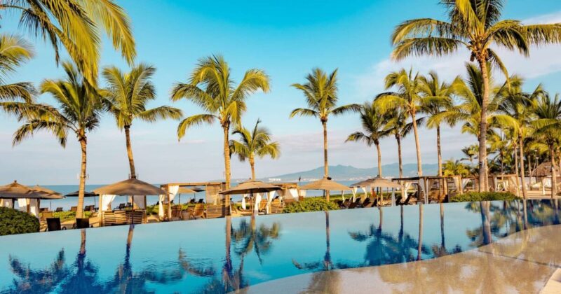 Poolside view at Accor Hotels' Marival Distinct All-Inclusive resort featuring cabanas and palm trees. Used as featured image for Accor sales and promotions.