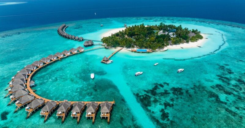 Aerial view of a Maldives resort with overwater bungalows and turquoise water, a top bucket-list destination.