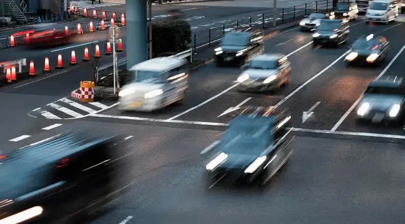 Imagem de diversos carros passando em velocidade em uma rodovia urbana para ilustrar artigo sobre pedágio free flow