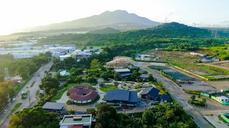 Aerial view of EcoWonder Park with gardens, walkways, and a thatched-roof building