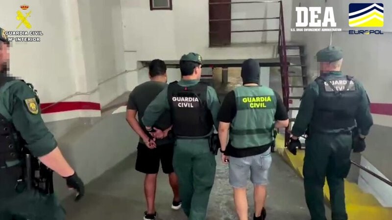 Agentes de la Guardia Civil deteniendo a dos personas en un aparcamiento, en Móstoles, Madrid.