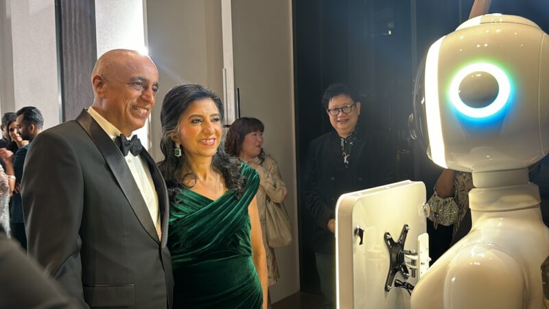 Couple smiling at the robot photo booth camera at an evening wedding