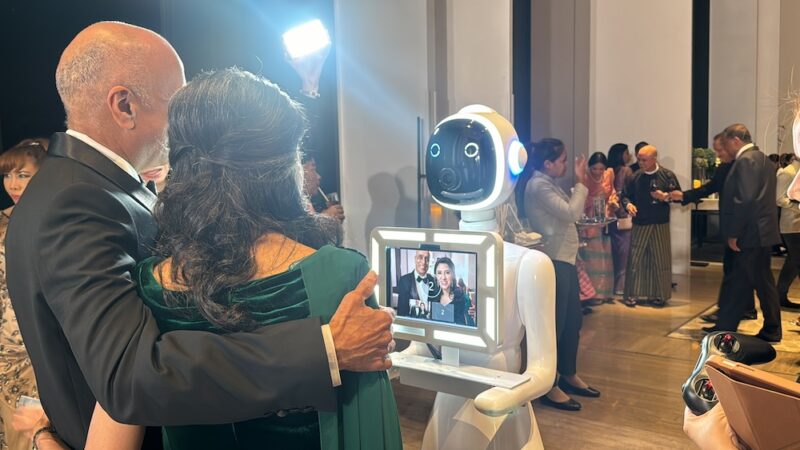 Guests hugging while the robot photo booth shows their photo on its screen