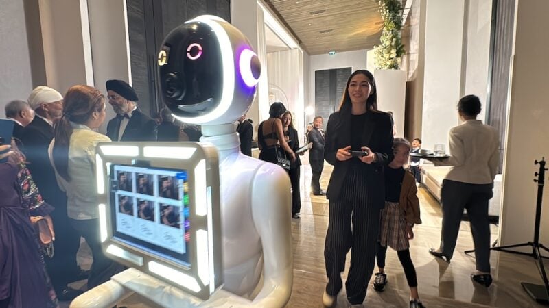 Robot photo booth screen showing a grid of guests' photos at a wedding