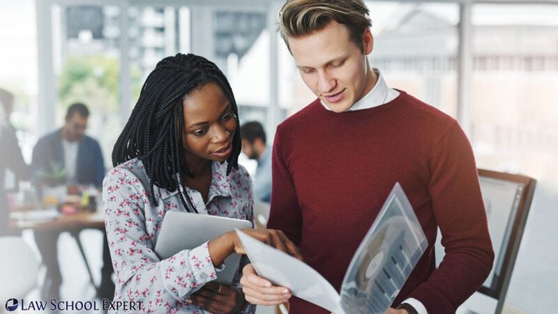 A man and woman review a document titled "Strategic Pre-Submission Strategies for Law School Success.