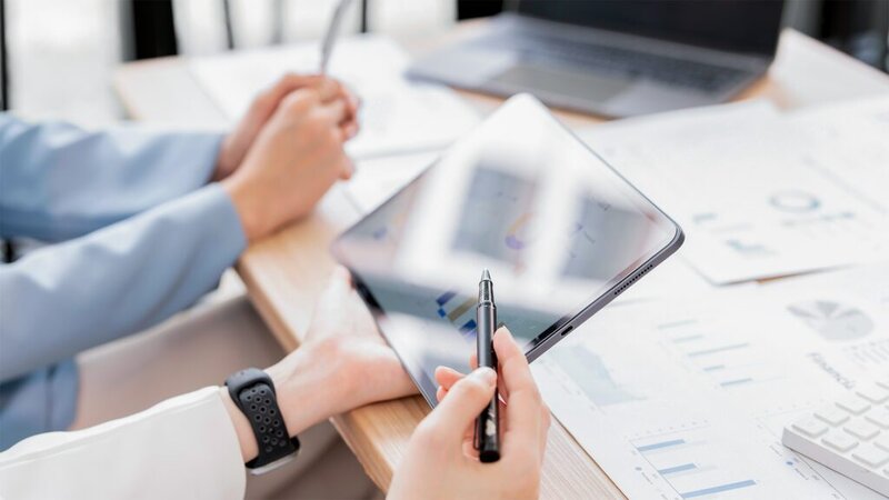 Zwei Personen, die vor einem Tablet sitzen und Statistiken zum Energieverbrauch angucken.