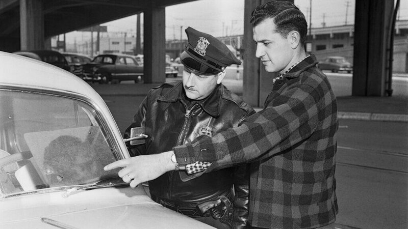 Police officers checking a car during a traffic stop.