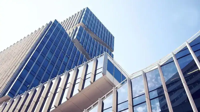 Edificio moderno acristalado con volúmenes escalonados y diseño urbano contemporáneo