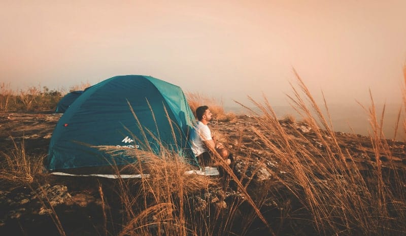 man sitting near the tent