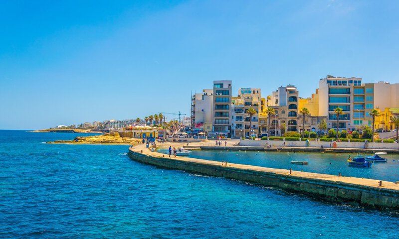 Mittelmeer-Küstenstadt mit moderner Architektur, Promenade und blauem Meer.
