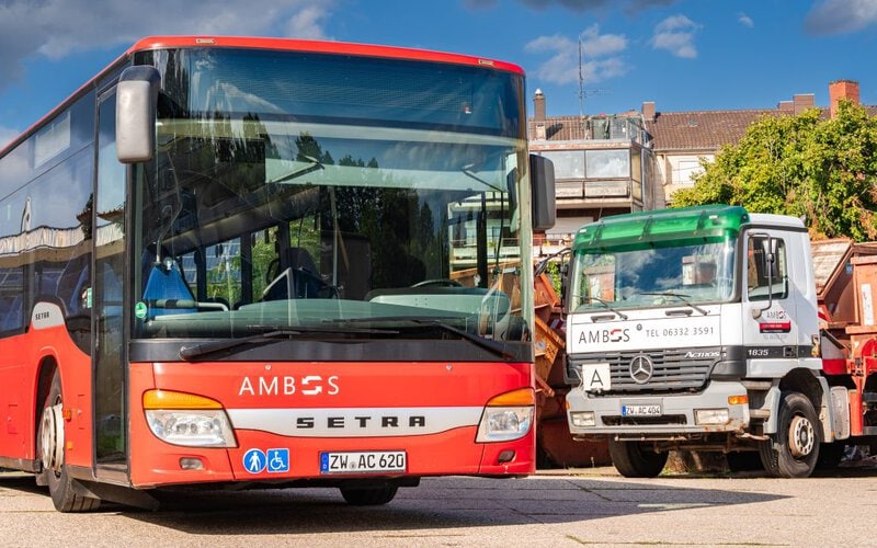Bus und Absetzkipper der Ambos GmbH auf dem Betriebsgelände in Zweibrücken.
