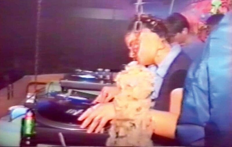Vintage VHS image of 90s rave DJ mixing on turntables during Club Telepathy night