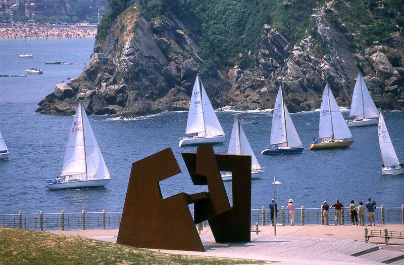 Segelboote in der Bucht von San Sebastián mit der Skulptur Peine del Viento im Vordergrund