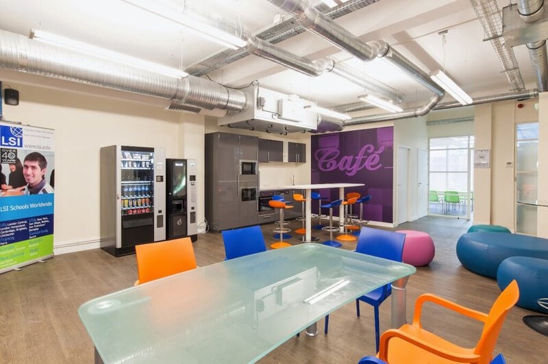 Moderne Aufenthaltslounge der LSI Sprachschule mit bunten Stühlen, einem Café-Bereich und Getränkeautomaten.