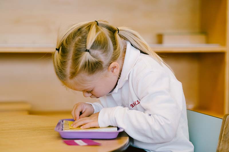 Little girl working in a Montessori classroom | Bishop Hamilton Montessori School in Ottawa