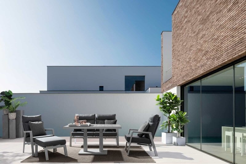 Arredamento esterno moderno su terrazza con piante e vista urbana.