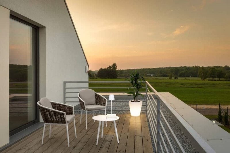 Situato su un edificio moderno, questo balcone offre una vista panoramica sulla campagna e un'atmosfera accogliente.