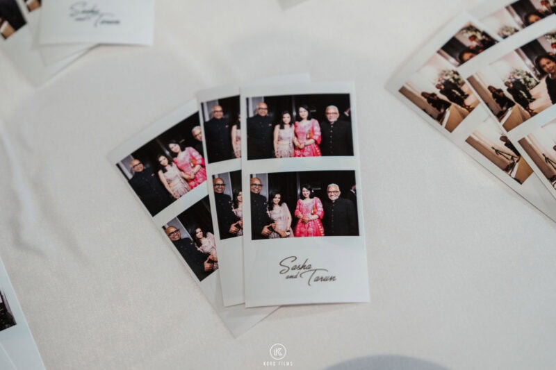 Photo booth prints and photo strips laid out for wedding guests in Thailand