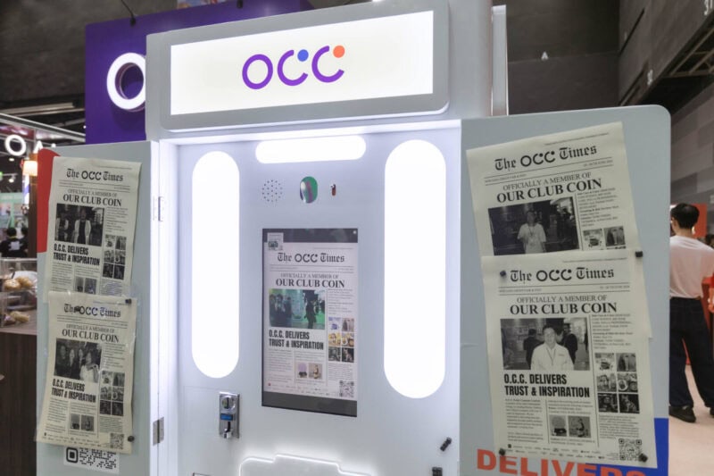 Newspaper photo booth at a Bangkok exhibition, with guests' front-page photo prints displayed on the booth panels