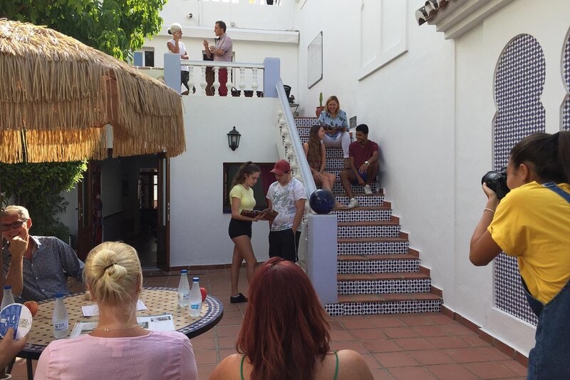 Lernende und Lehrkräfte im traditionellen Innenhof der Sprachschule in Nerja bei Gesprächen und Aktivitäten