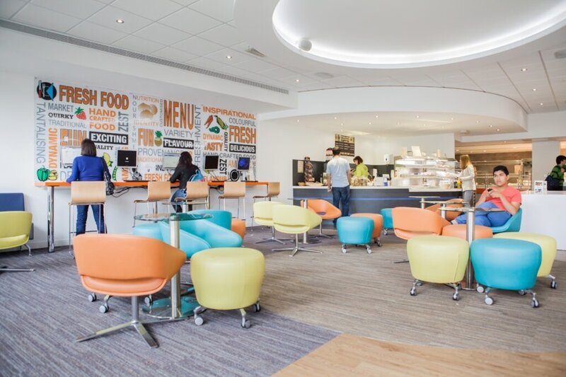 Moderne Studentenlounge mit farbenfrohen Sitzmöbeln und Cafébereich