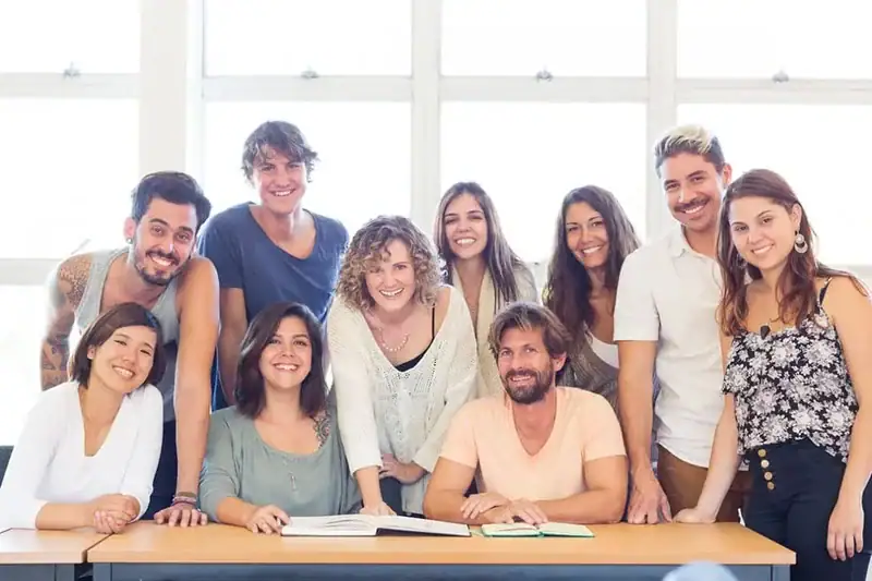 Eine Gruppe internationaler Studierender in einem hellen Klassenzimmer, lächelnd und motiviert beim gemeinsamen Lernen.