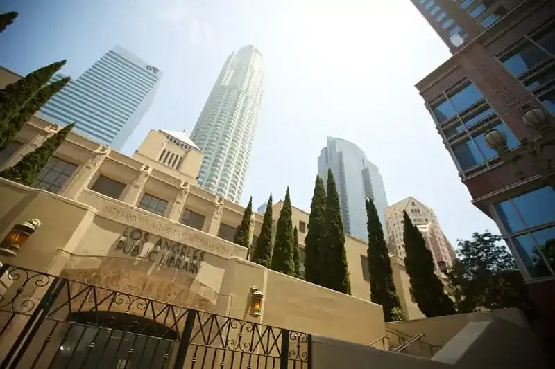Die Los Angeles Public Library mit modernen Wolkenkratzern im Hintergrund, aufgenommen aus einer niedrigen Perspektive.