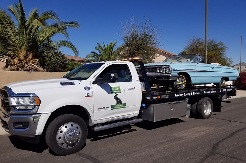 Freeway Towing & Storage flatbed tow truck transporting classic car in Phoenix, Arizona - comparing flatbed vs wheel-lift towing methods