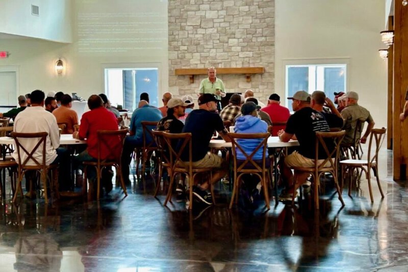 Ameren team meeting at round tables in front of the stone fireplace in the Grand Hall at Romaine Valley