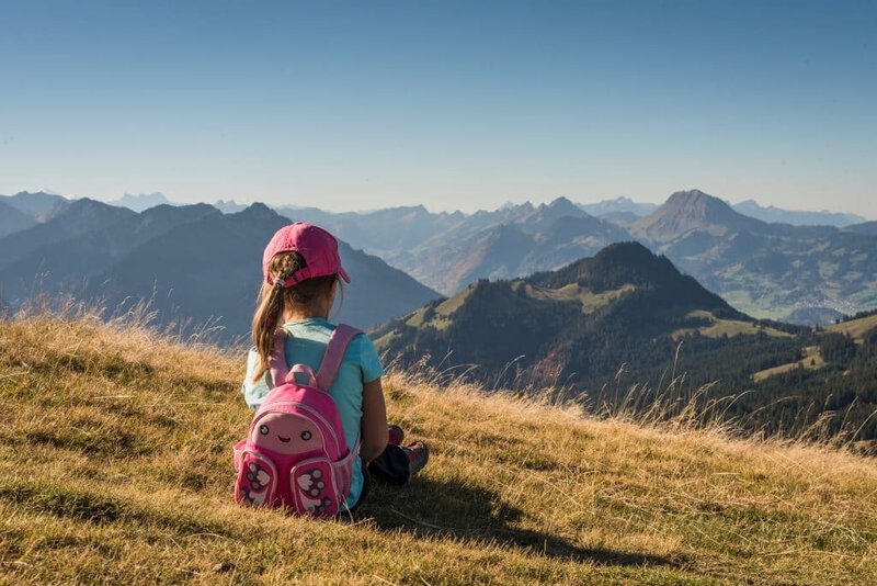 Child enjoying a mountain view after hiking with the best kids travel backpack