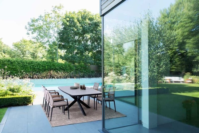 Piscina e area esterna moderna con mobili eleganti, vista sui giardini verdi, ambiente perfetto per il relax all'aperto.