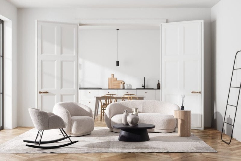 Soggiorno elegante con divani bianchi e arredi moderni, luce naturale e atmosfera accogliente in stile scandinavo.