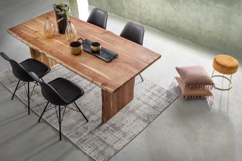 Tavolo in legno naturale per sala da pranzo elegante e moderna, abbinato a sedie nere e decorazioni in stile minimal.