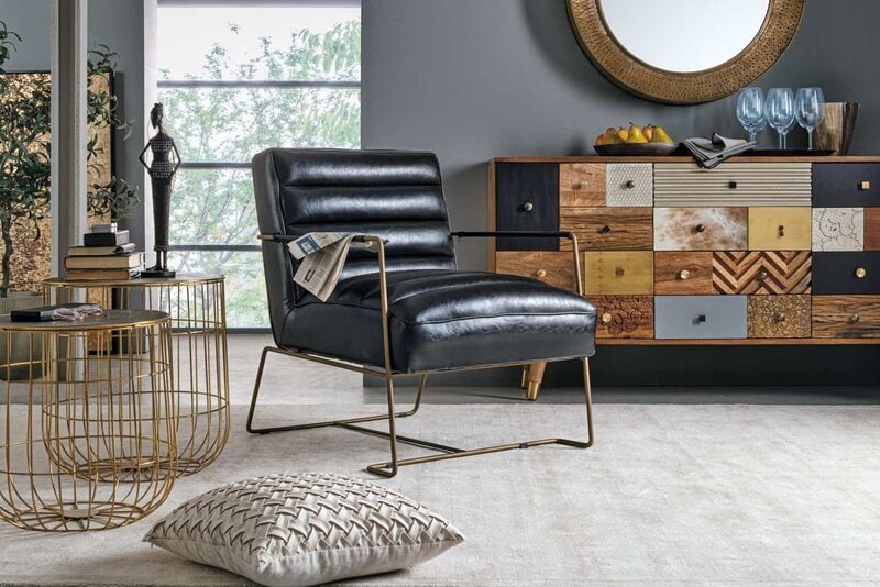 Sedia moderna in pelle nera con struttura in metallo dorato, perfetta per ambienti eleganti.