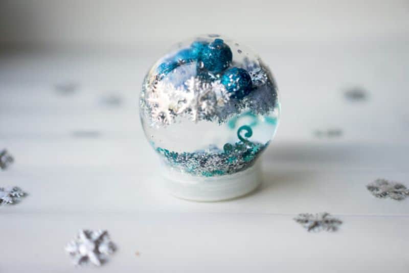 plastic jar filled with tinsel balls and snowflake charms