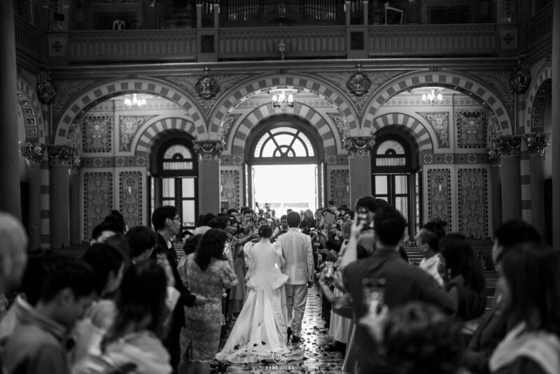Black and white photo of a church wedding ceremony by Koro Films