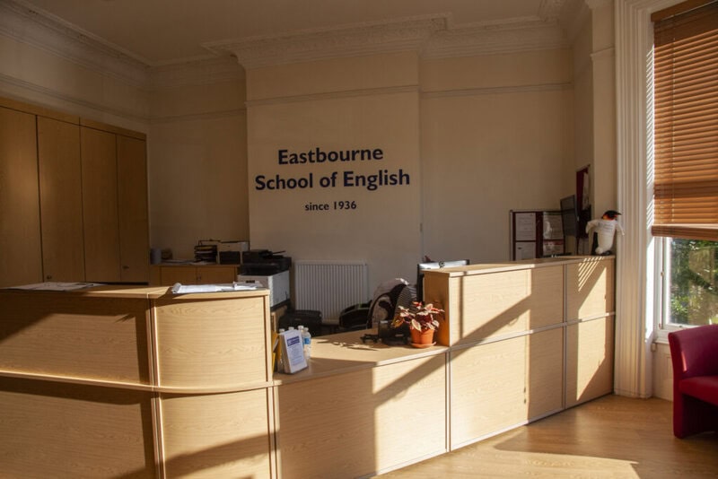 Empfangsbereich der Eastbourne School of English mit moderner Rezeption, hellen Holzmöbeln und freundlicher Atmosphäre.