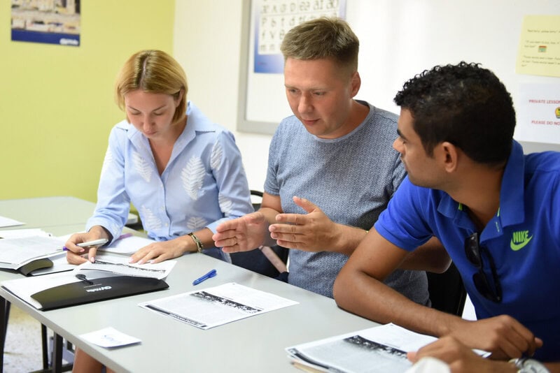 Internationale Sprachschüler arbeiten gemeinsam im Unterricht an einer Lernaufgabe.
