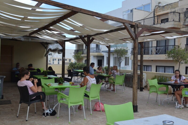 Gemütliche Terrasse mit Sitzgelegenheiten, auf der Sprachschüler entspannt lernen und sich austauschen.