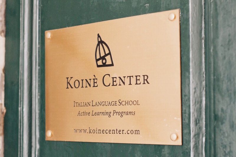 Messingschild mit dem Logo und Namen des Koinè Center – einer italienischen Sprachschule für aktive Lernprogramme.