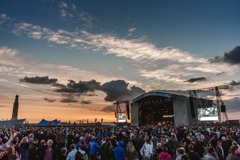 Große Menschenmenge beim Victorious Festival in Portsmouth vor der Hauptbühne bei Sonnenuntergang.