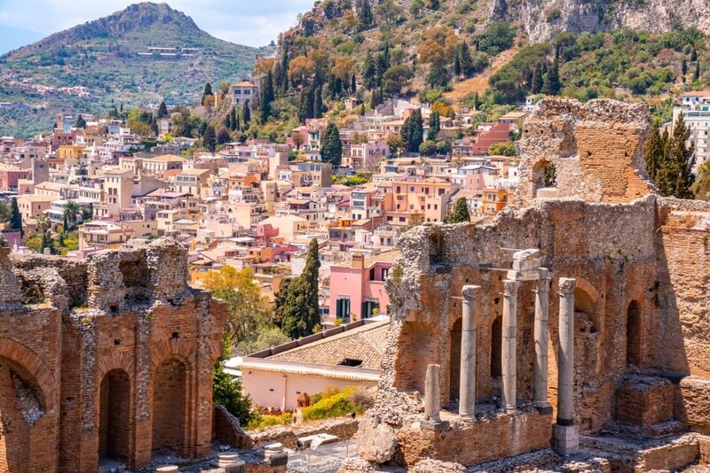 Antikes griechisches Theater von Taormina mit Blick auf die malerische Stadt und die umliegenden Hügel Siziliens.