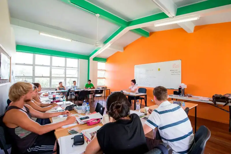 Sprachschulklasse mit internationalen Schülern in einem farbenfrohen Klassenzimmer mit moderner Ausstattung.
