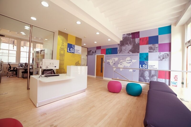 Moderne Empfangshalle einer Sprachschule mit buntem Design und einladender Atmosphäre.