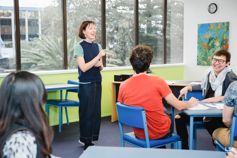 Fröhliche Unterrichtsstunde in der LSI-Sprachschule mit einer engagierten Lehrerin und internationalen Sprachschülern.