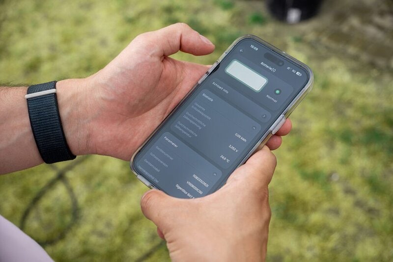 Darstellung eines Smartphones in der Hand, auf dem Bildschirm ist das Energiemanagement-System zu sehen.